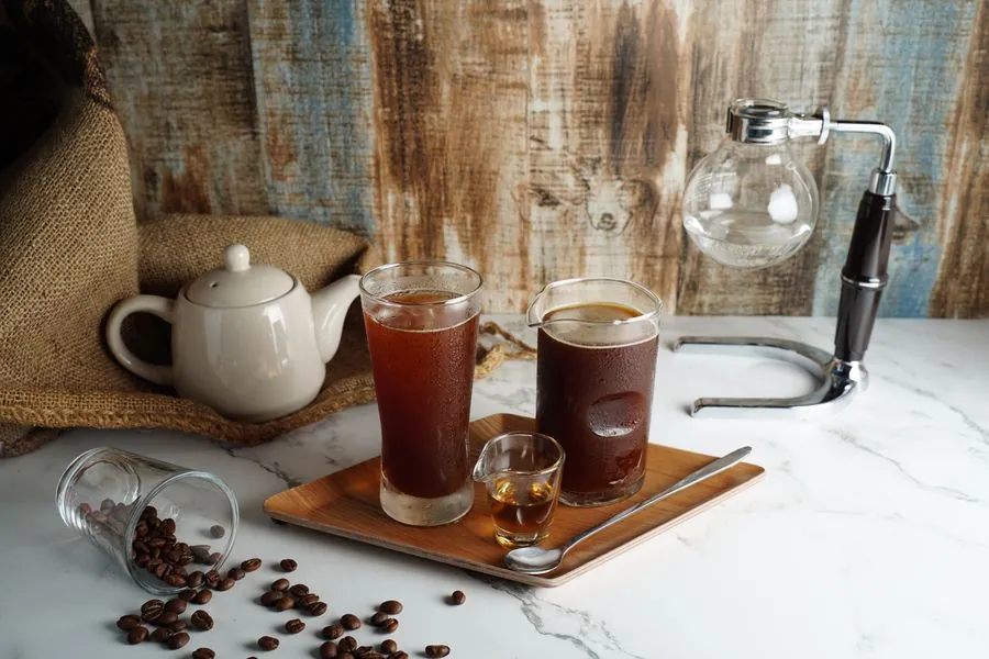 Iced coffees with beans on a wooden board