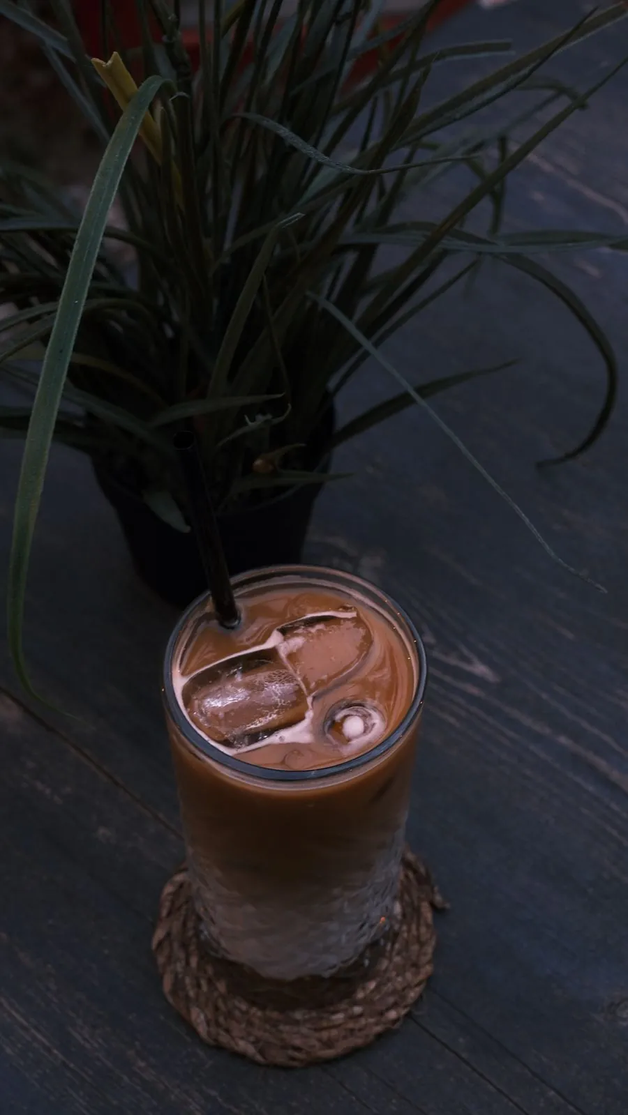 An iced macadamia milk coffee on a dark counter