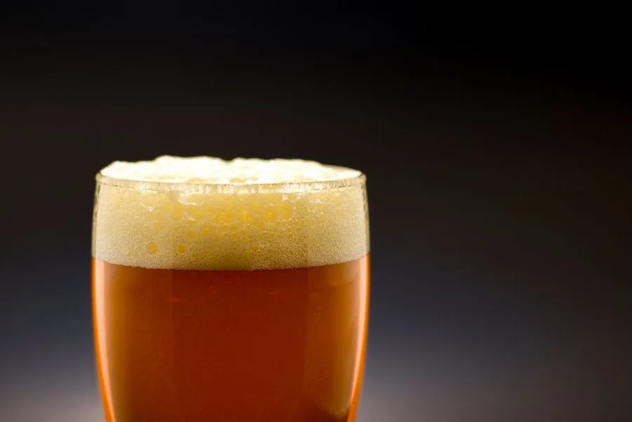 A glass of dark nitro cold brew with a velvet cascading head